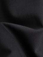 Black T-shirt fabric close-up with sleeve fold texture