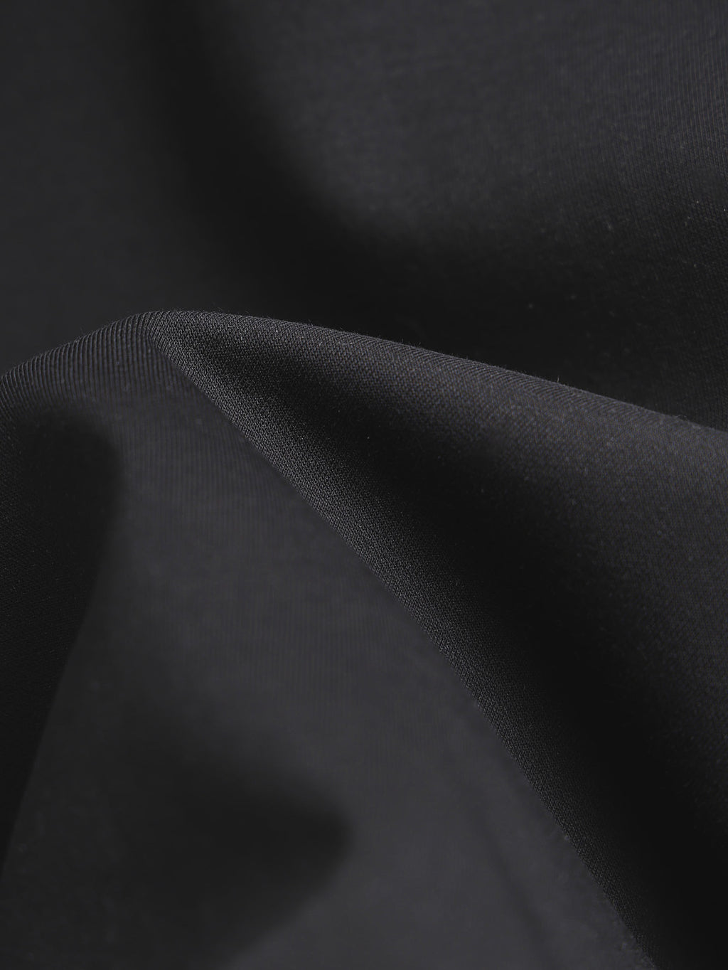 Black T-shirt fabric close-up with fine textured weave