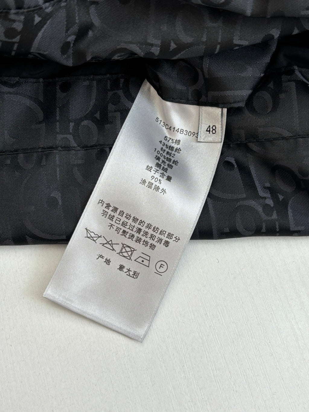 Clothing care label on dark quilted Dior monogram jacket with black button