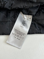 Clothing care label on dark quilted Dior monogram jacket with black button