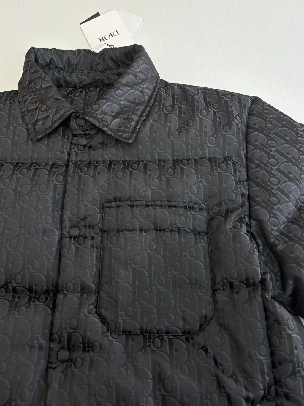 Dior long puffer jacket, dark navy, close-up of quilted monogram fabric and collar
