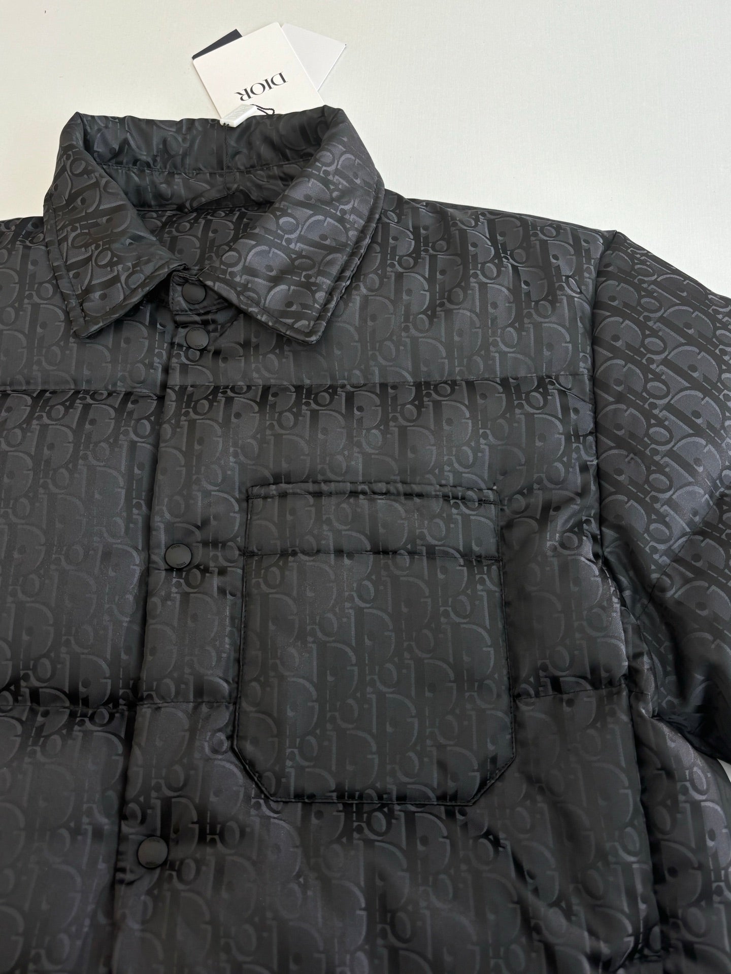 Dior long puffer jacket, dark navy, close-up of quilted monogram fabric and collar