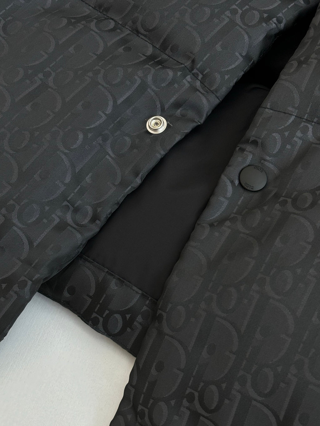 Dior long puffer jacket, dark navy, close-up of snap placket and monogram fabric