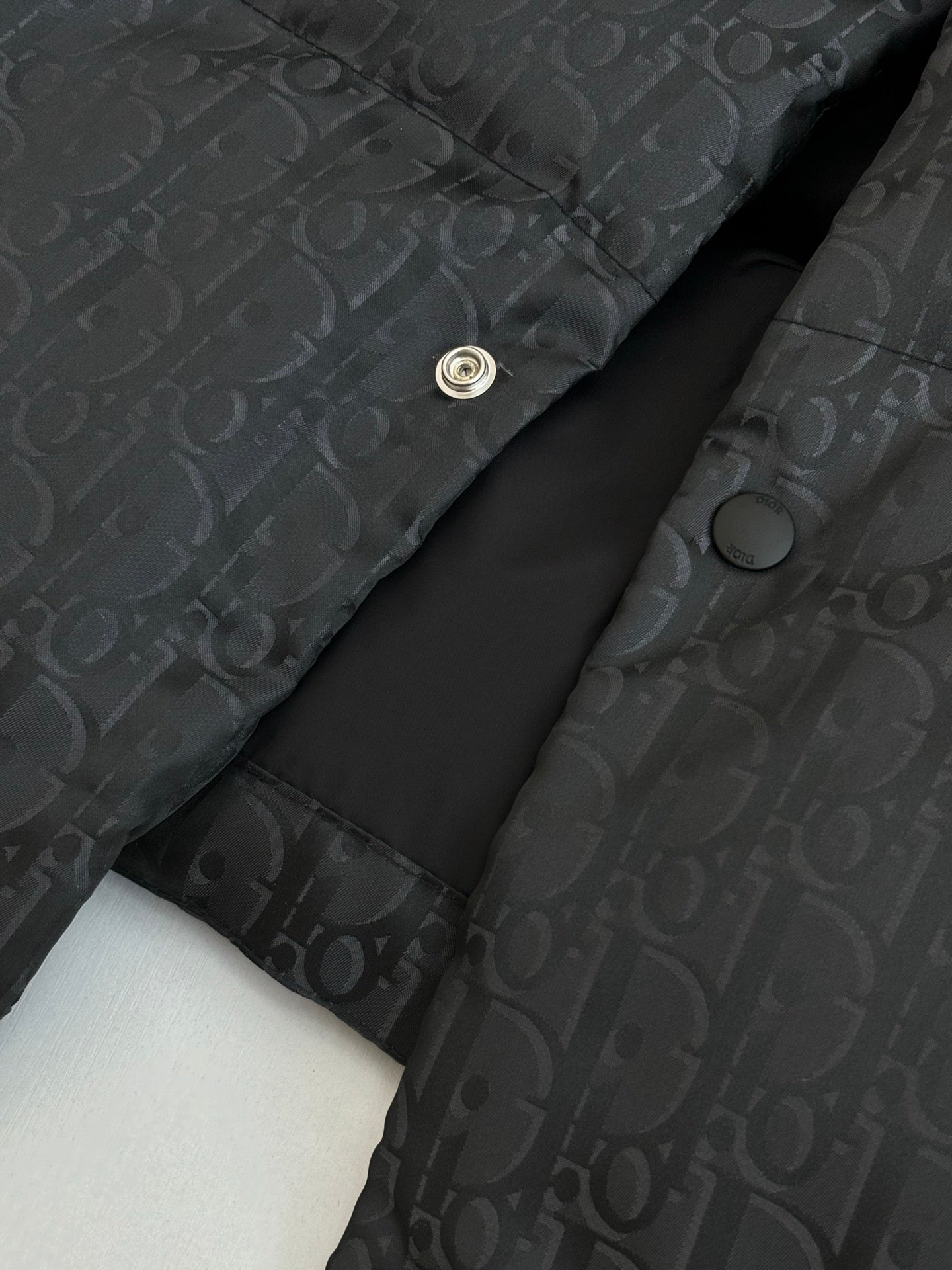 Dior long puffer jacket, dark navy, close-up of snap placket and monogram fabric