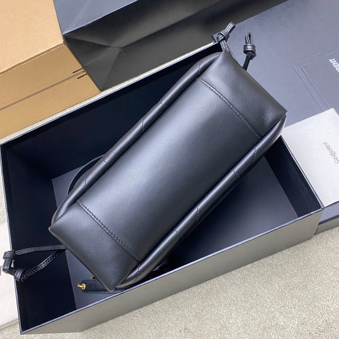 Black YSL leather shoulder bag with stitched panels and adjustable strap