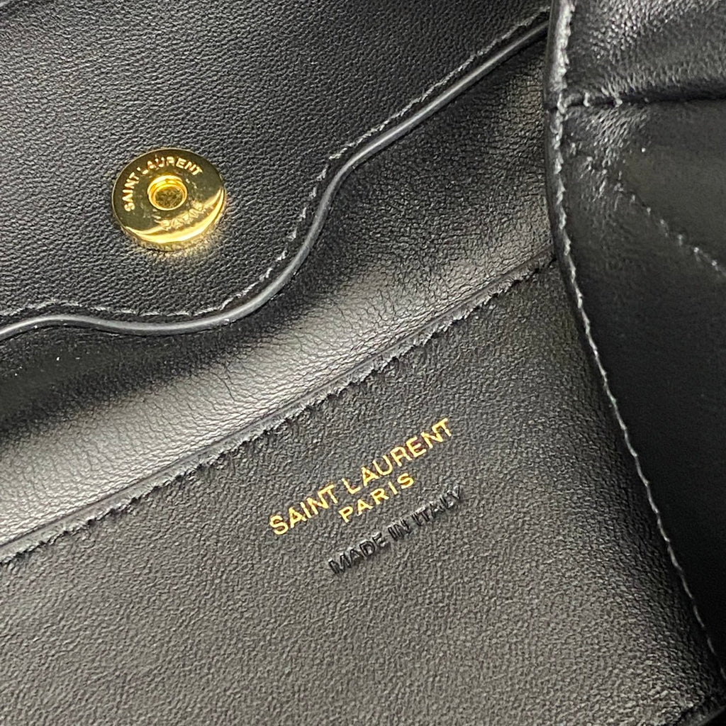“SAINT LAURENT PARIS” stamped on black YSL leather near logo hardware