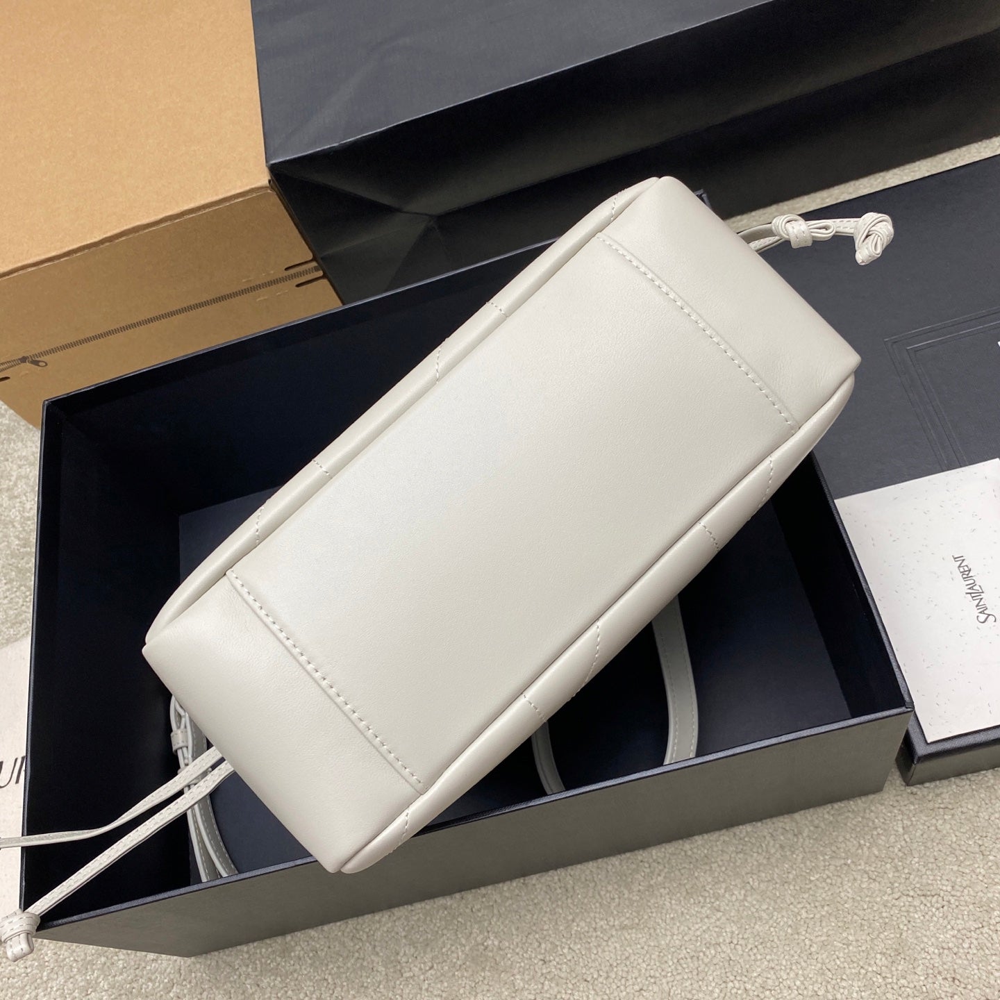 YSL bag in white leather with stitched trim and adjustable crossbody strap