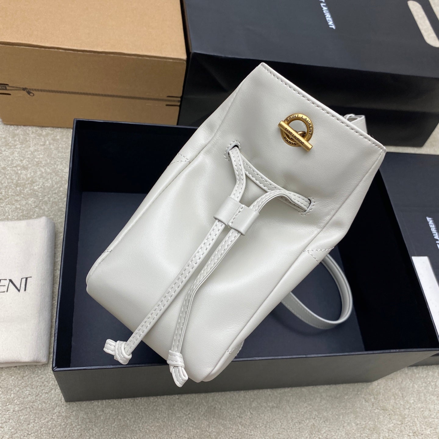 YSL bag white leather with gold monogram detail, top handle, and strap loops