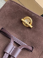 YSL bag suede close-up with gold Saint Laurent Paris tag and leather strap
