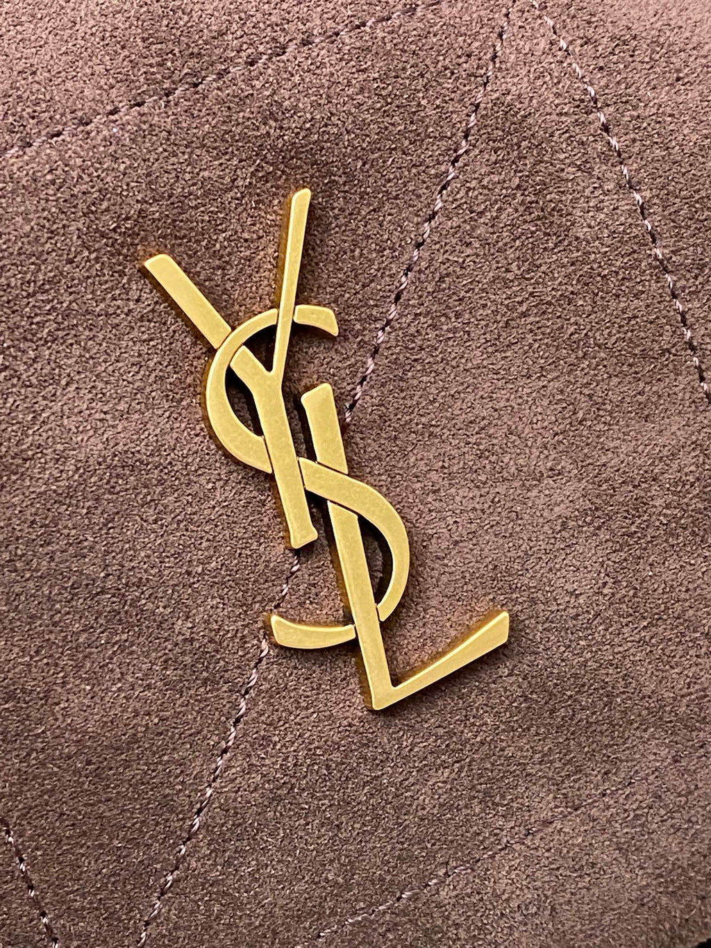 YSL logo emblem in gold on taupe suede bag