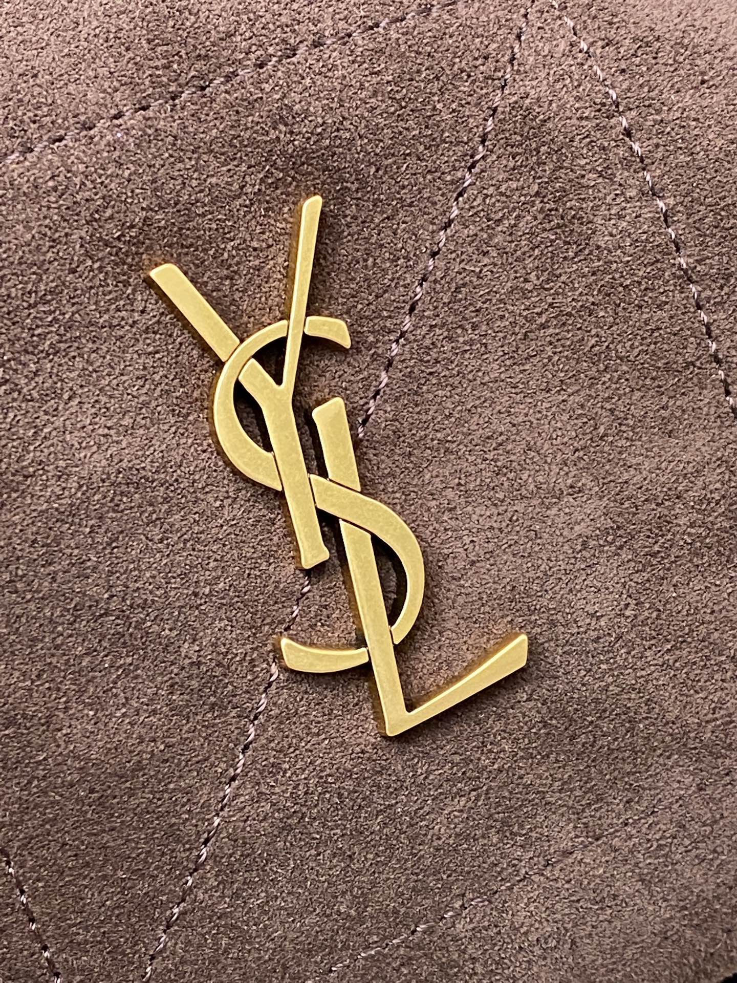 YSL logo emblem in gold on taupe suede bag