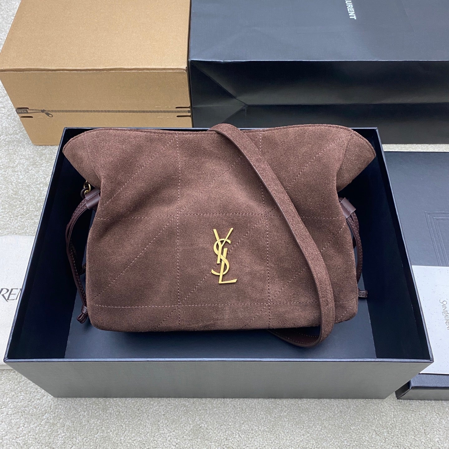 YSL bag in taupe suede with gold YSL logo on front flap