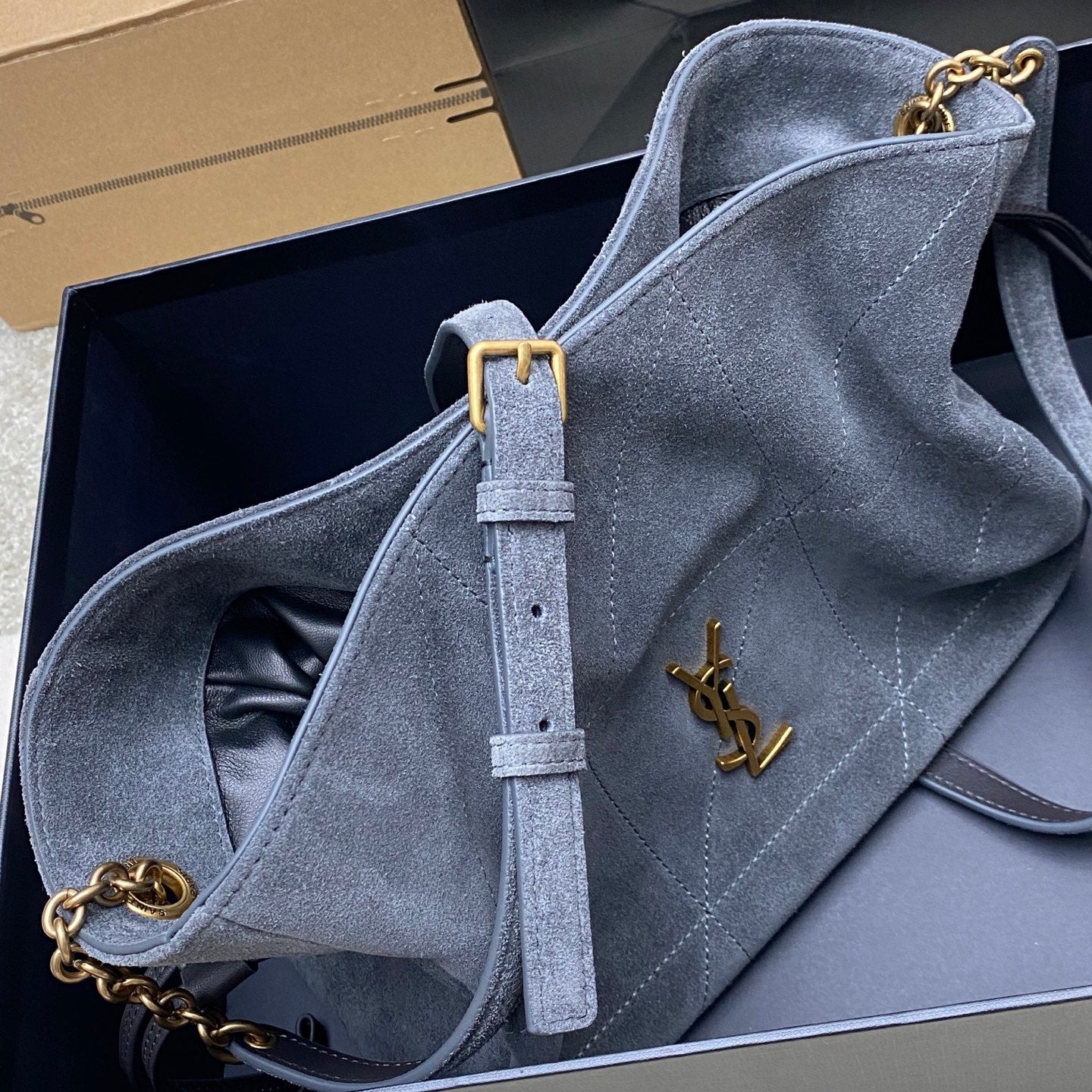 Blue-gray suede YSL bag with chain strap and gold YSL logo on front