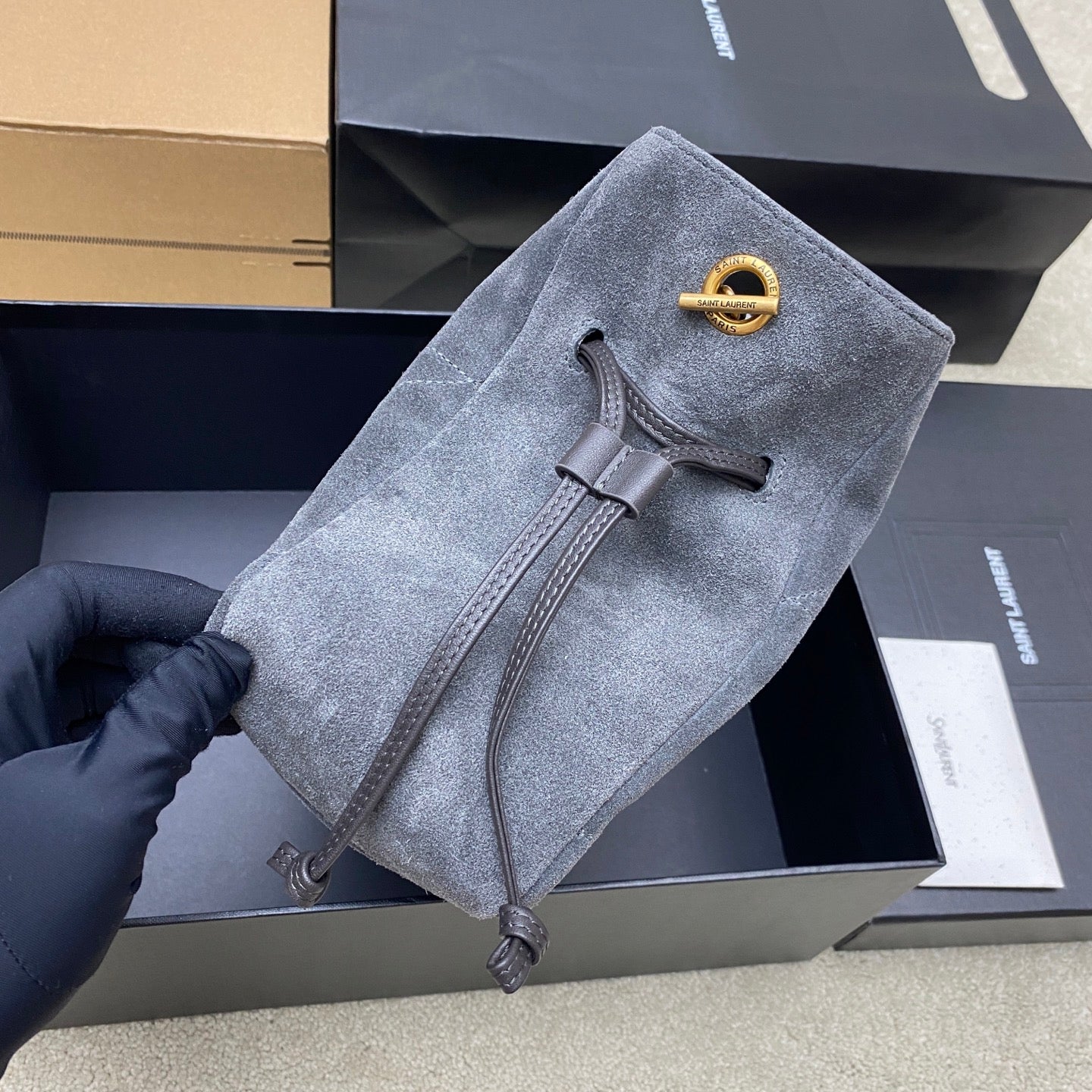 Blue-gray suede YSL bag with gold logo, clasp flap, and leather-trim strap