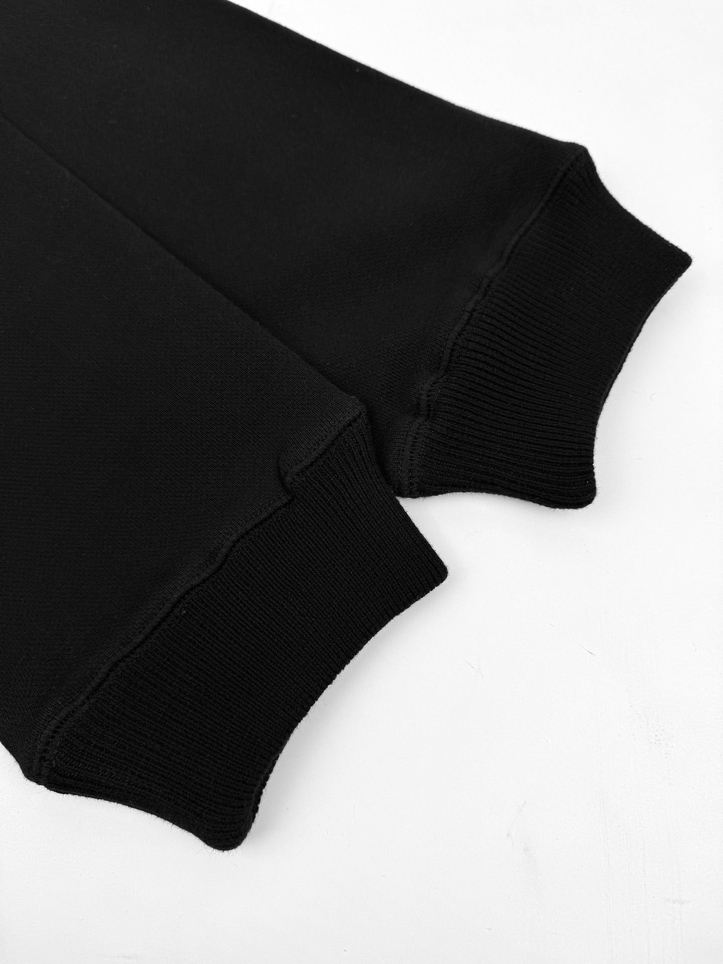 Black hoodie sleeves with ribbed cuffs and curved hem