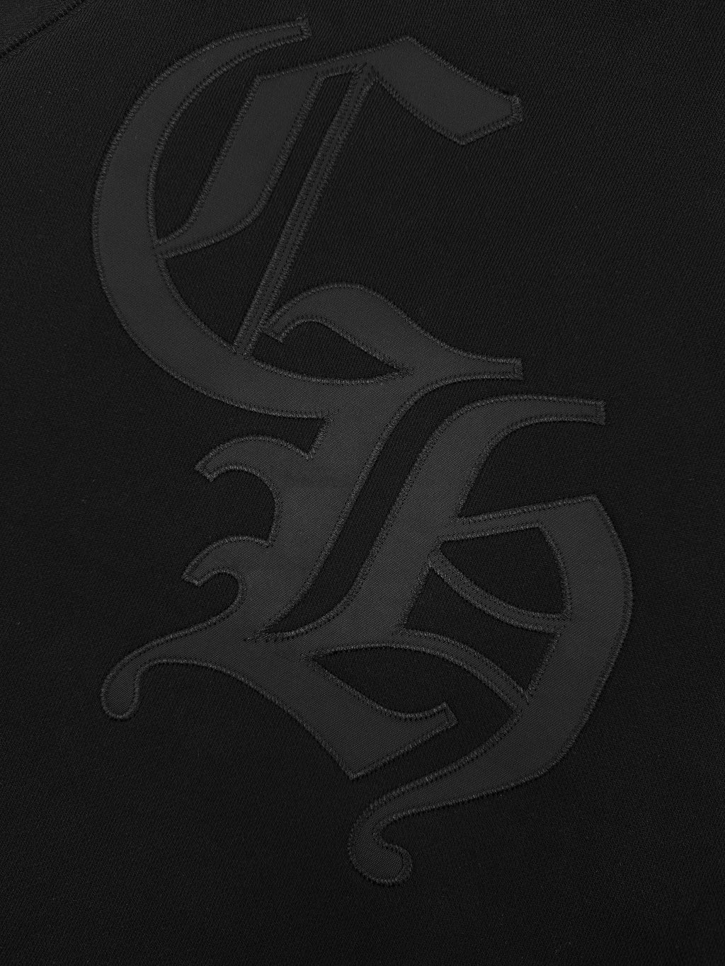 Black hoodie with large dark graphic logo on chest