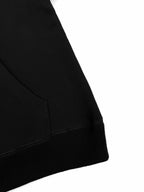 Black hoodie lower front with stitched seams and ribbed bottom hem