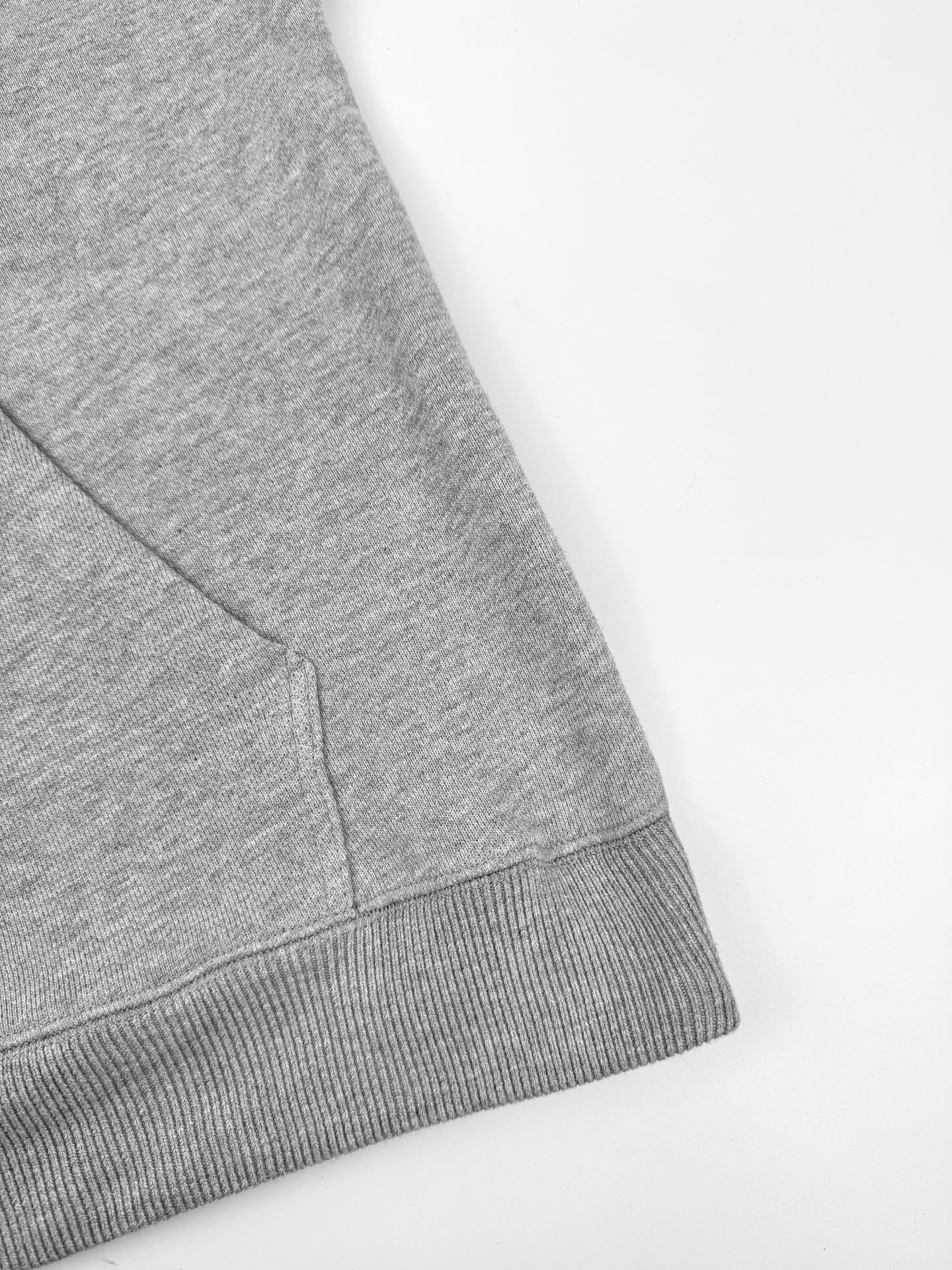 Gray hoodie hem with ribbed trim and side seam detail.