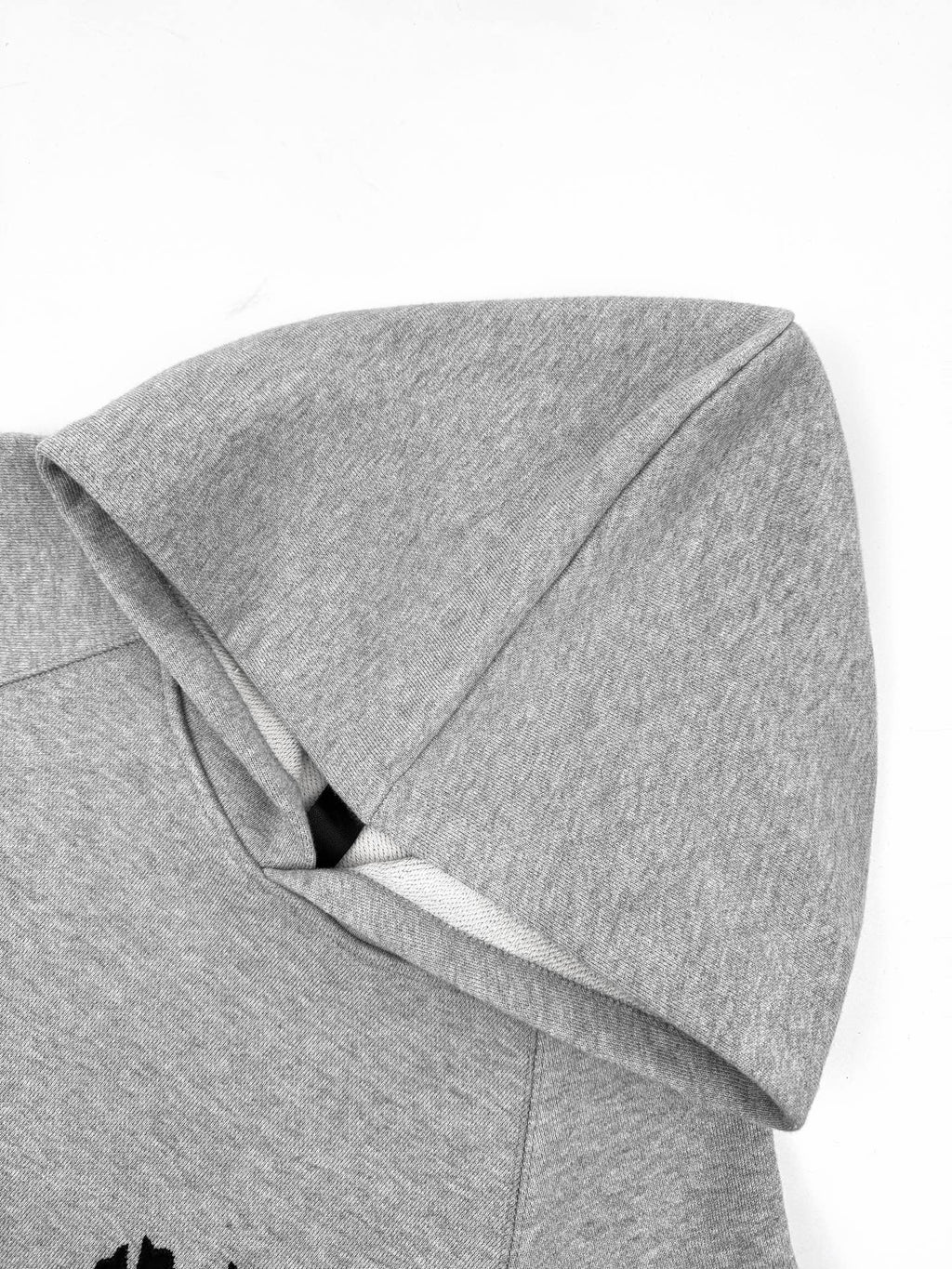 Gray hoodie close-up of hood and seam detail.