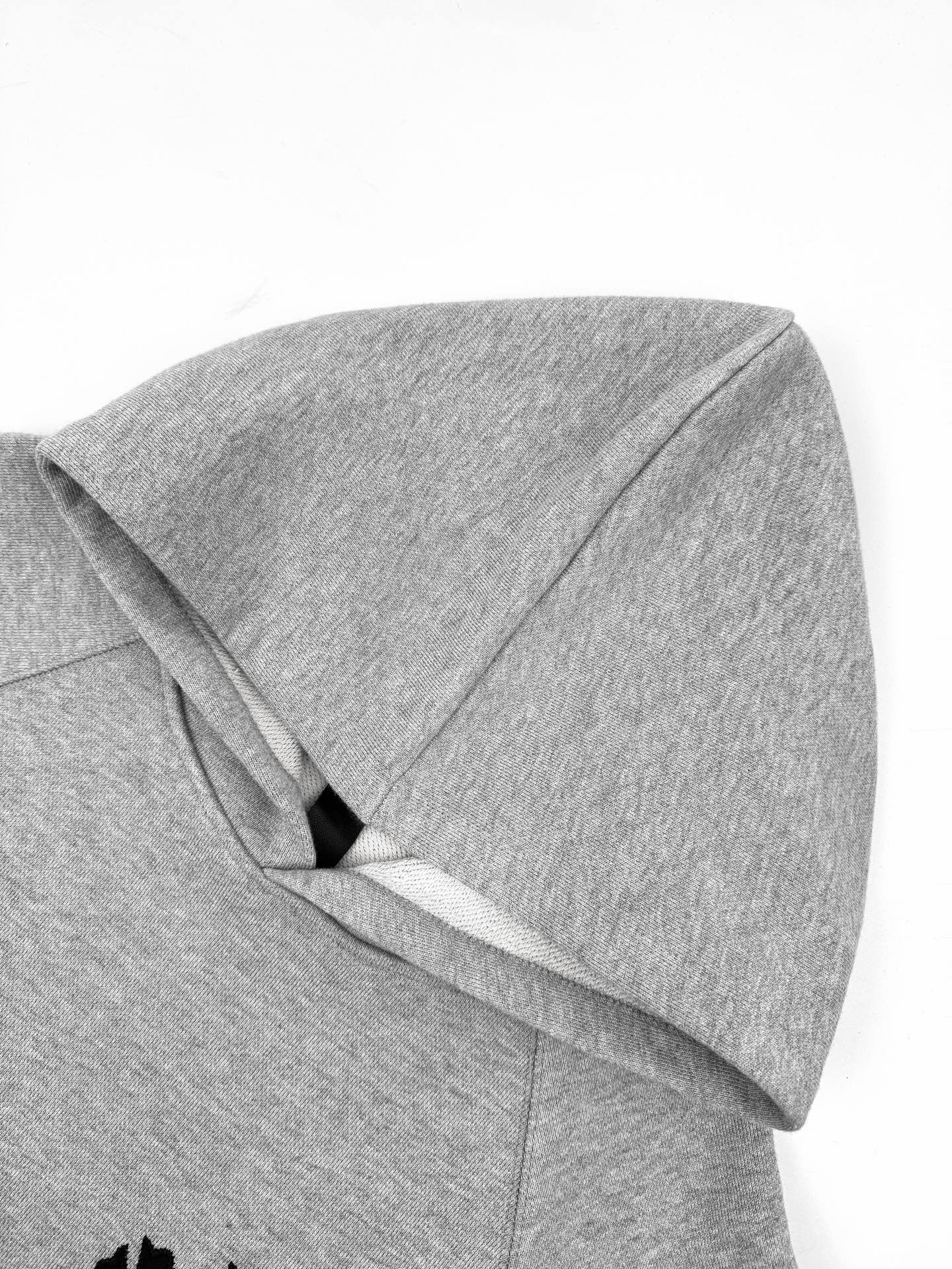 Gray hoodie close-up of hood and seam detail.