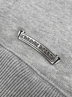 Gray hoodie tag close-up with embossed brand lettering.
