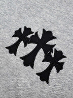Gray hoodie fabric close-up with black embroidered logo.
