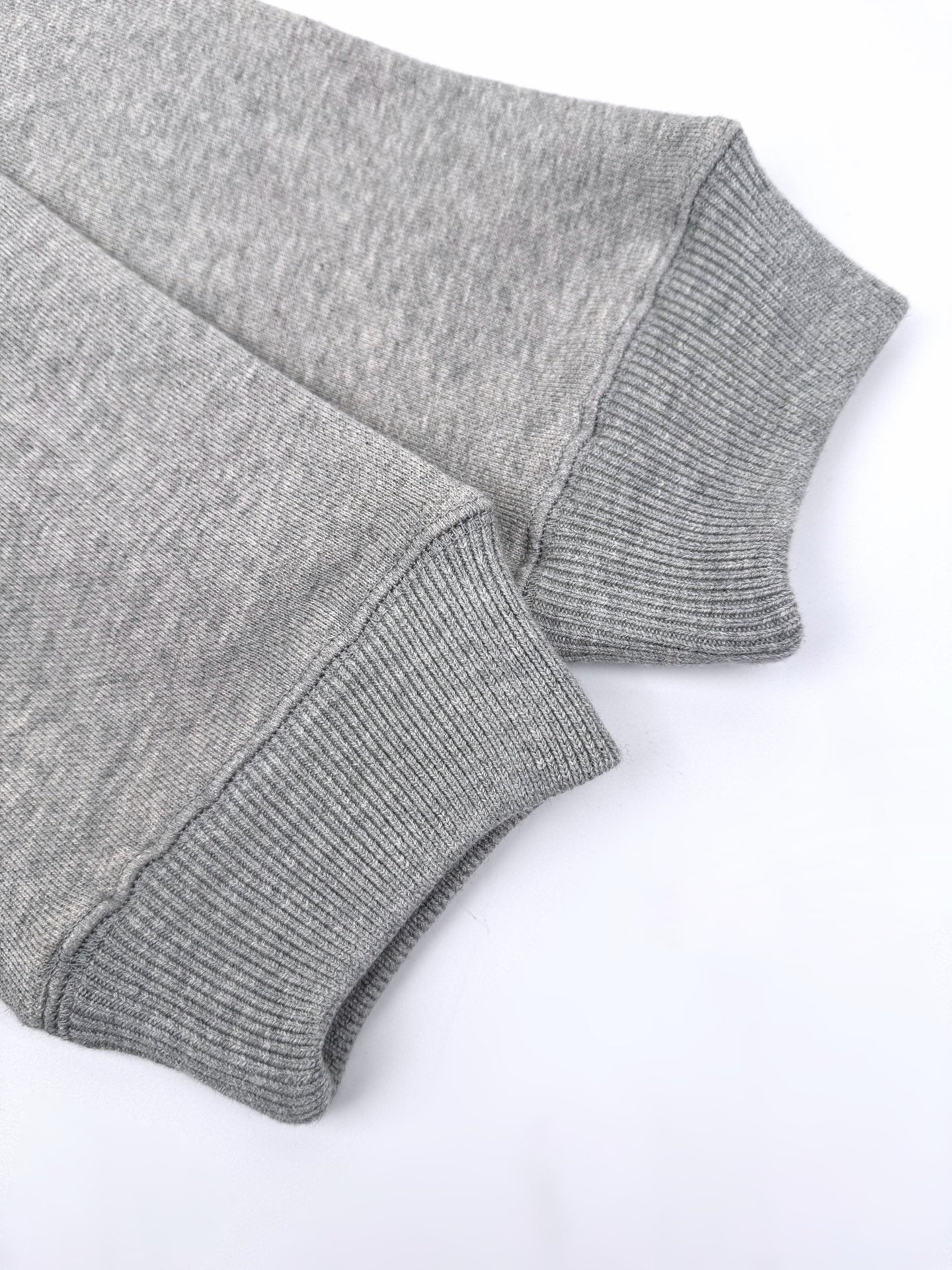 Gray hoodie sleeve and ribbed cuff close-up.