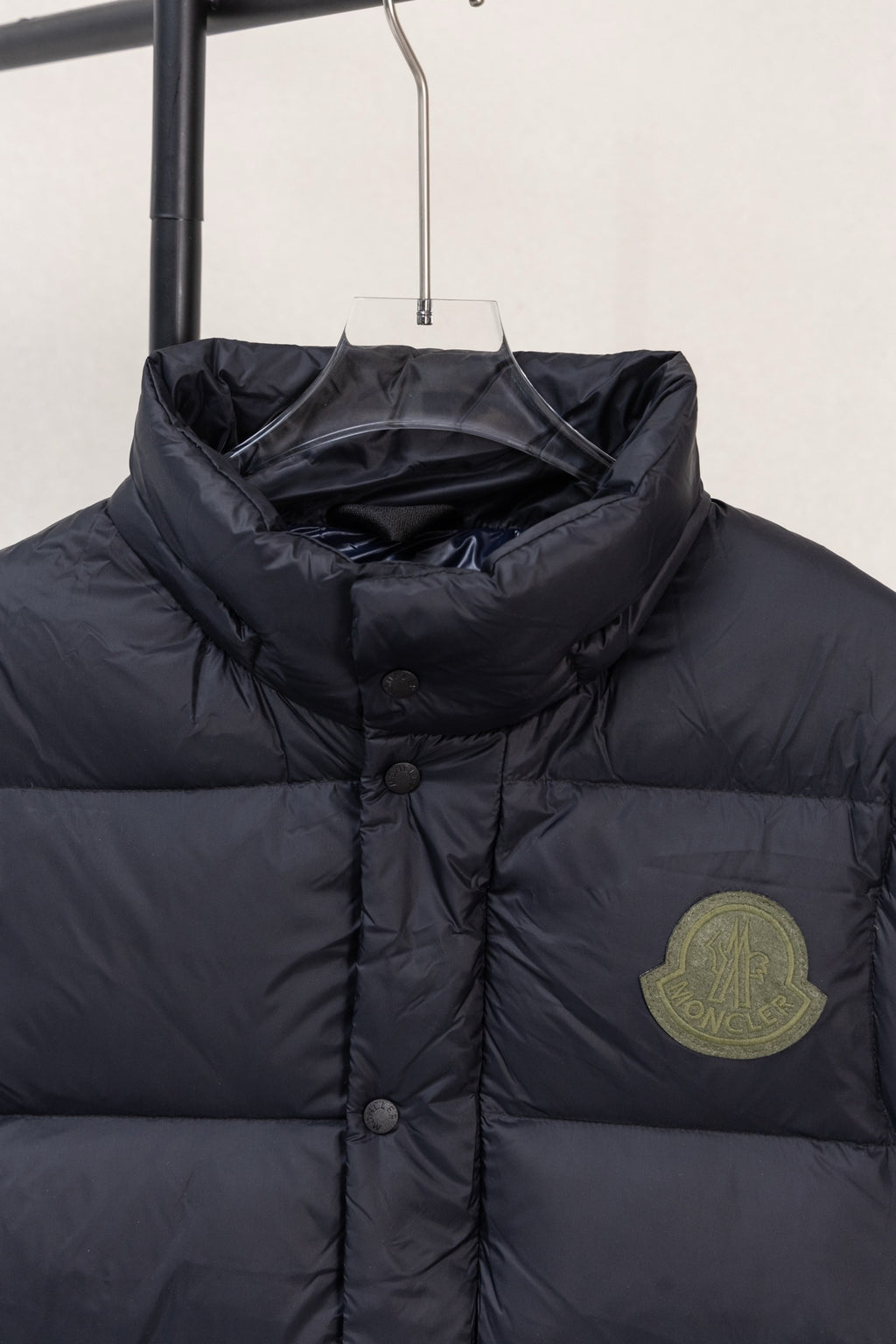 Moncler dark puffer jacket chest area with round buttons and logo patch