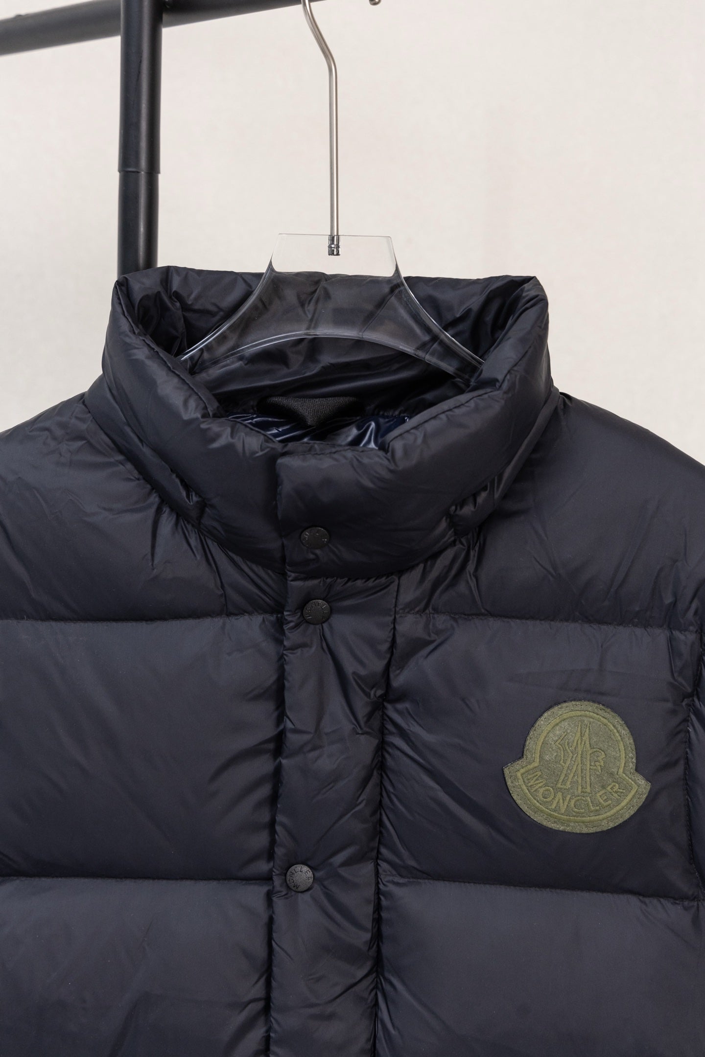 Moncler dark puffer jacket chest area with round buttons and logo patch