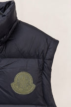 Moncler dark puffer vest front with raised logo patch and stitched side panels