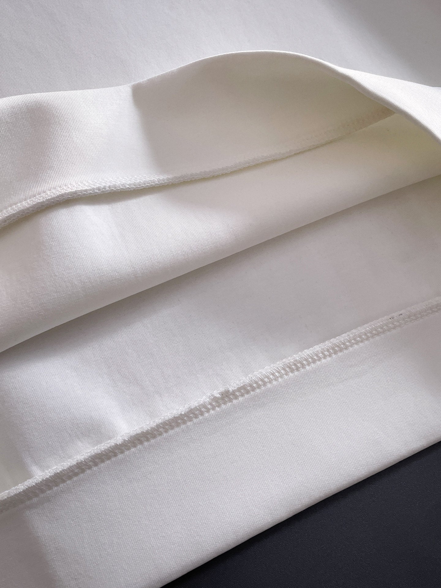 White sweatshirt hem and seam close-up with visible stitching
