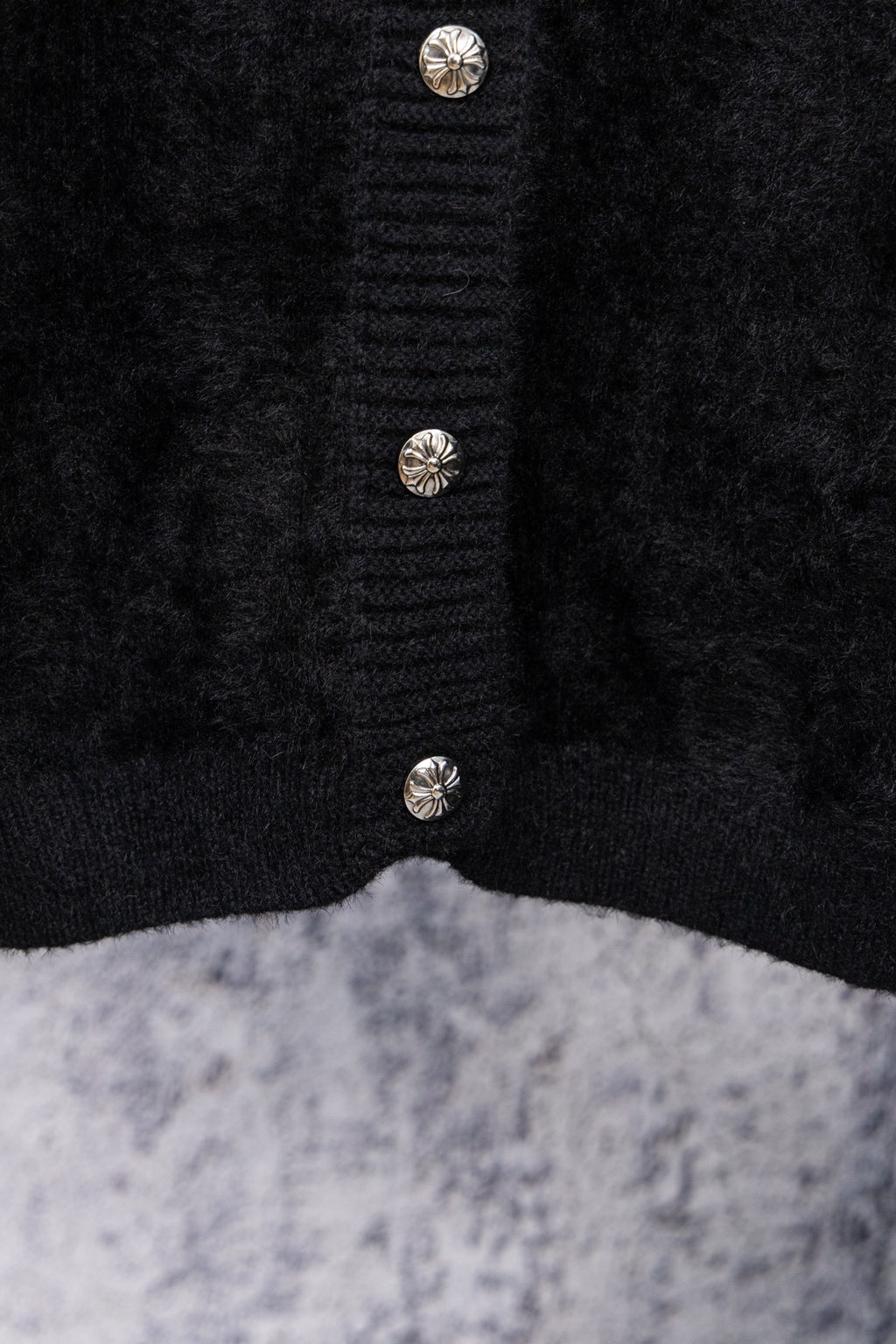 Black cardigan center front with three decorative metal button accents