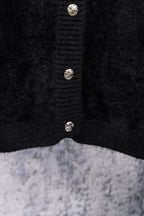 Black cardigan center front with three decorative metal button accents