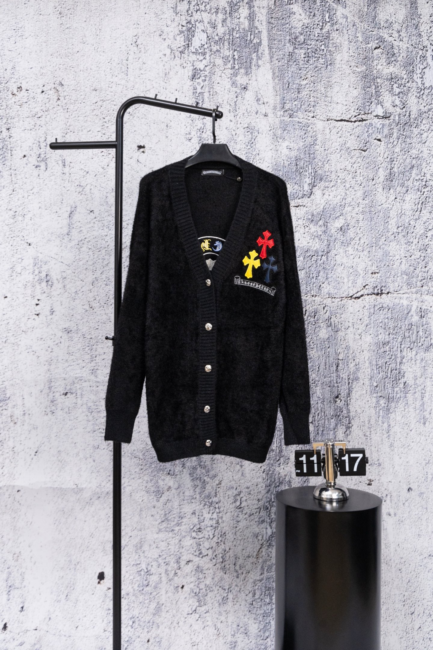 Black long-sleeve cardigan with button front and colorful embroidered chest patches