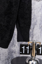 Black long-sleeve top, visible lower torso and sleeve cuff seam