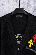 Black cardigan neckline with embroidered emblem patches and button front detail