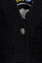 Black cardigan button placket with silver-toned button and embroidered insignia