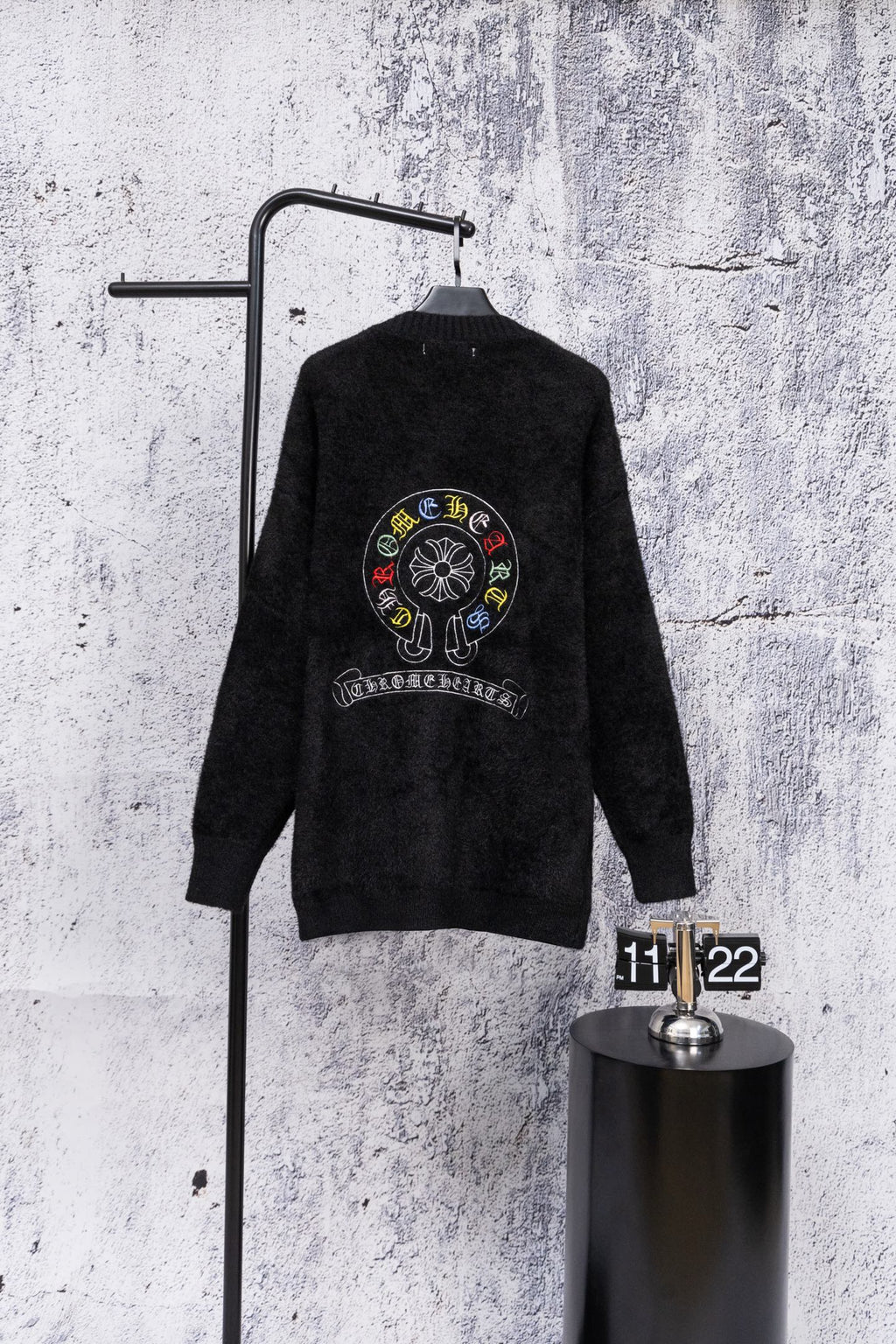 Black long-sleeve cardigan with large circular back crest embroidery and button placket