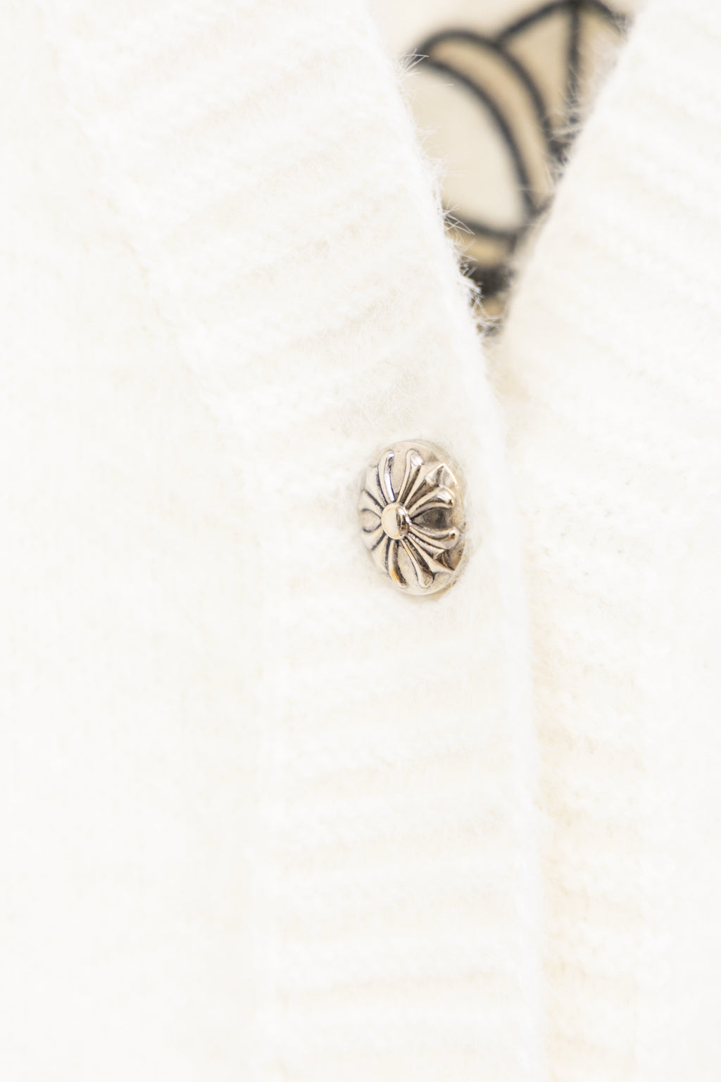 White cardigan sweater close-up of shell-style button on front