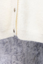 White cardigan sweater close-up of button placket and fabric texture