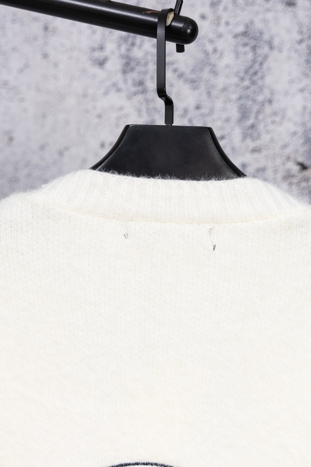 White long-sleeve top on hanger, ribbed neckline