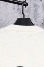 White long-sleeve top on hanger, ribbed neckline