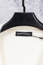 White cardigan sweater neckline label with black trim on hanger