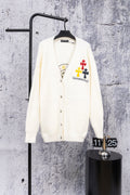 White cardigan sweater with button front and colorful chest patch