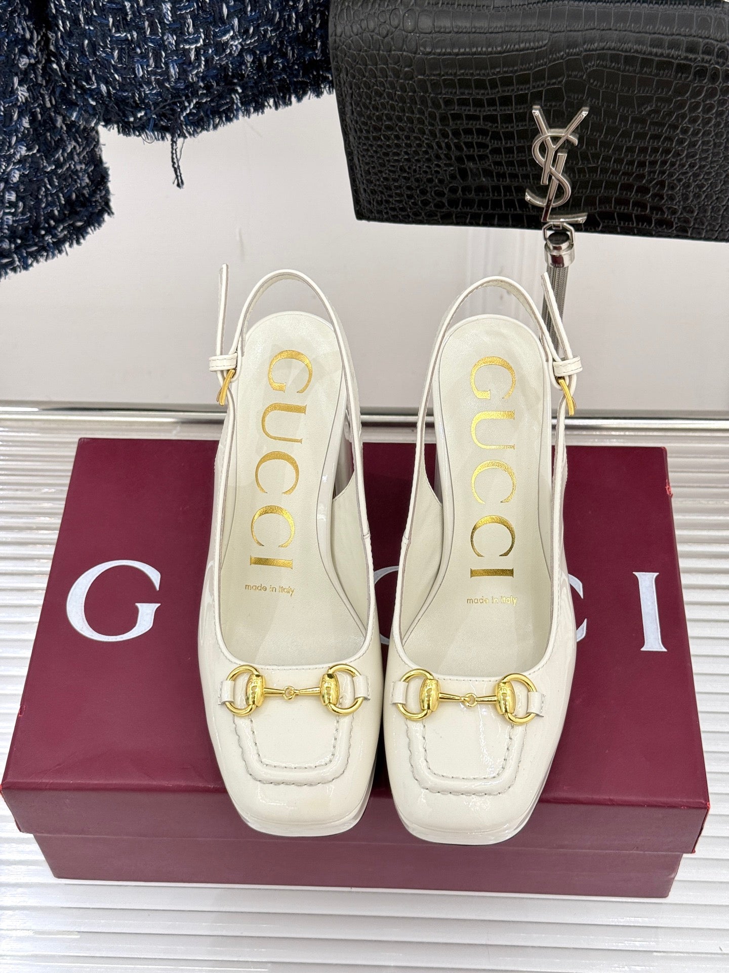 Cream leather heeled platform-style loafers with gold chain accent on uppers