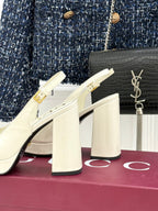 Cream heeled loafers with gold chain trim and thick block heel, side view