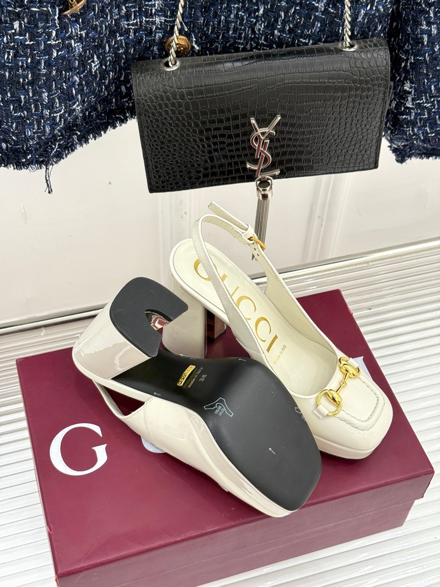 Cream leather heeled loafers with gold chain hardware and open-toe mule profile