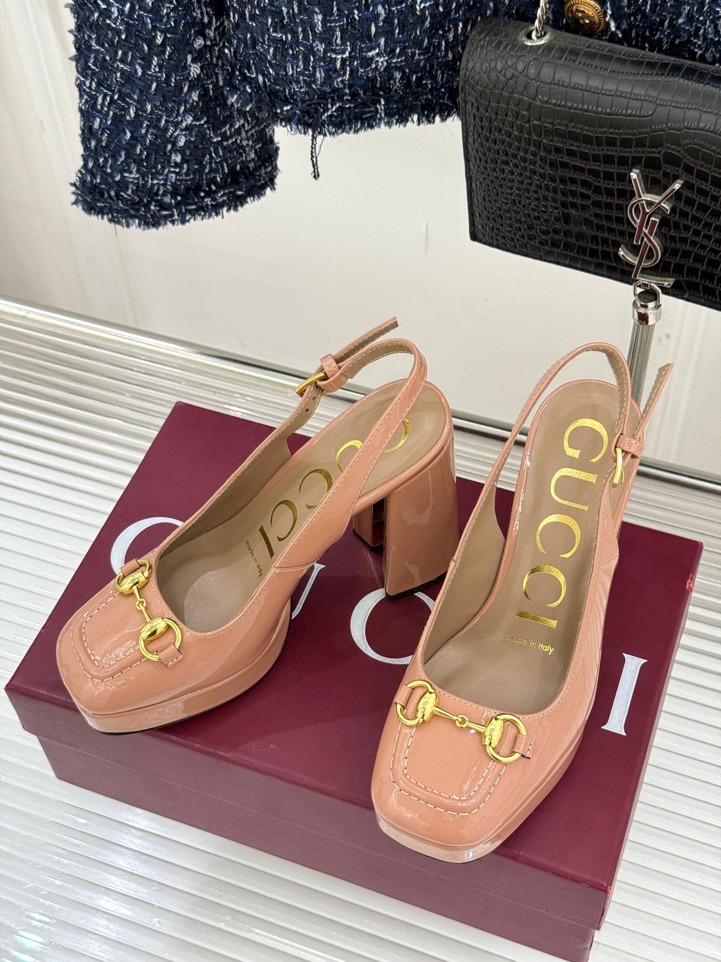 Light pink slingback pumps with chunky heel and gold horsebit buckle, side view