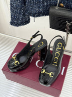 Pair of Gucci black patent heeled shoes with gold chain-link detail and sling straps