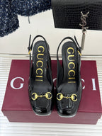 Gucci black patent heeled shoes with gold horsebit detail and molded heel support